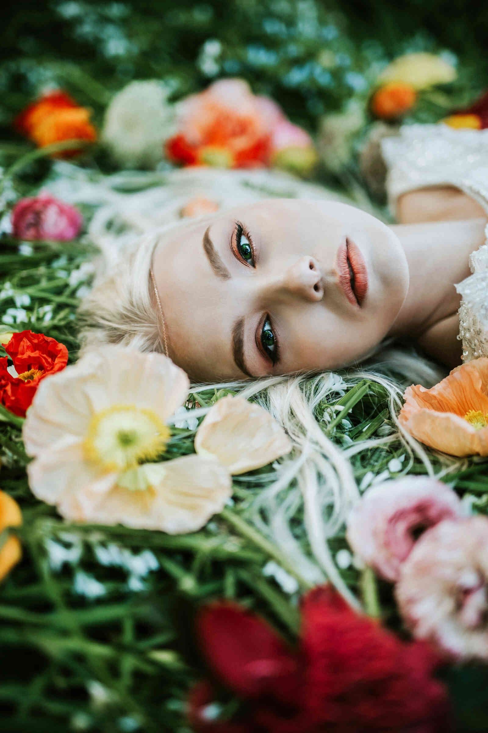 bride_laying_in_grass_close_up_vibrant_flowers_c5813b9797