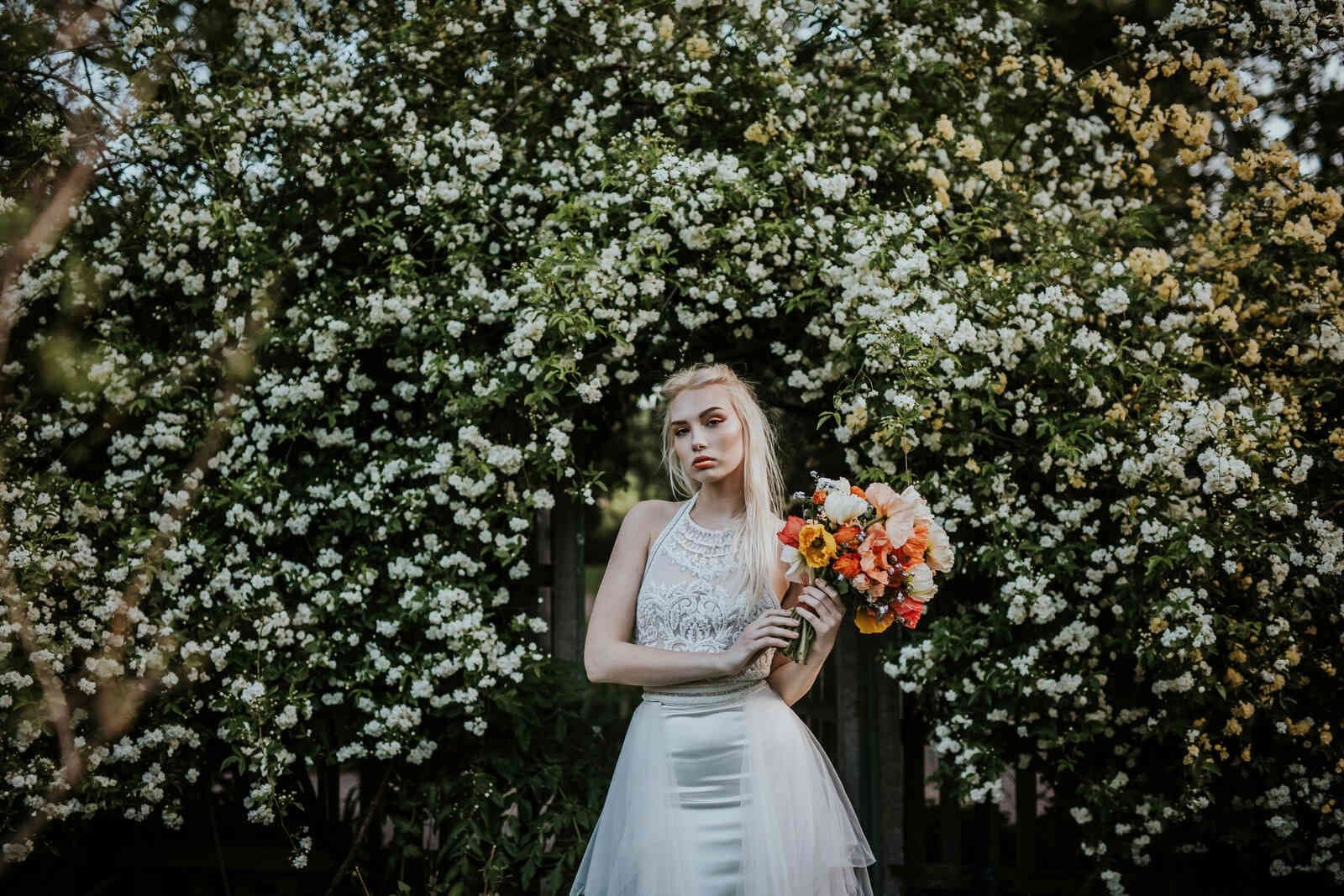 bride_portrait_archway_white_blossoms_colorful_bouquet_21ab971ed7