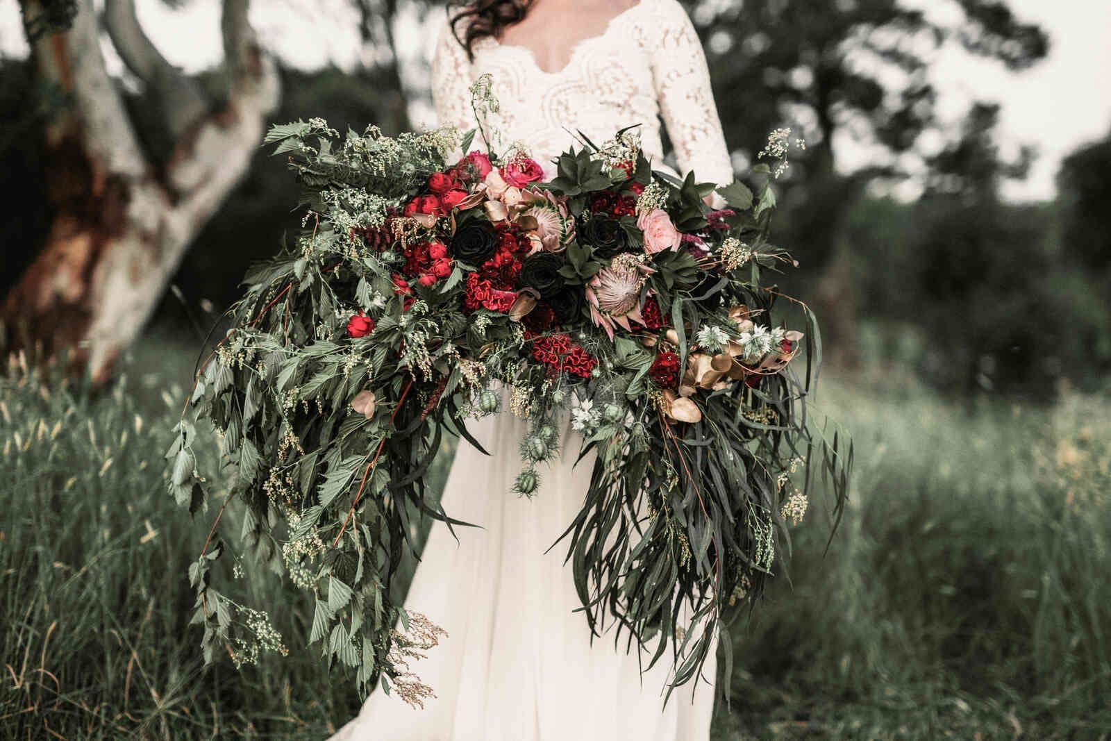 bride_holding_huge_red_greenery_bouquet_61ab84ae37