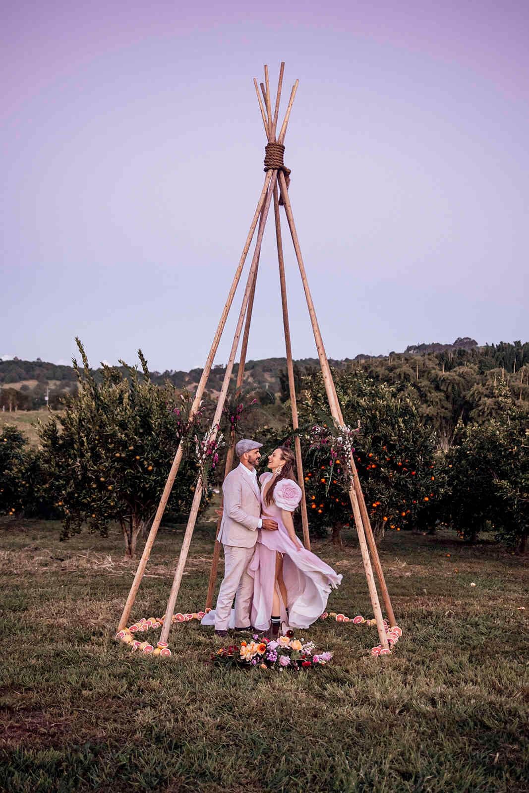 bride_groom_kissing_teepee_arch_orchard_twilight_portrait_5127ffed55