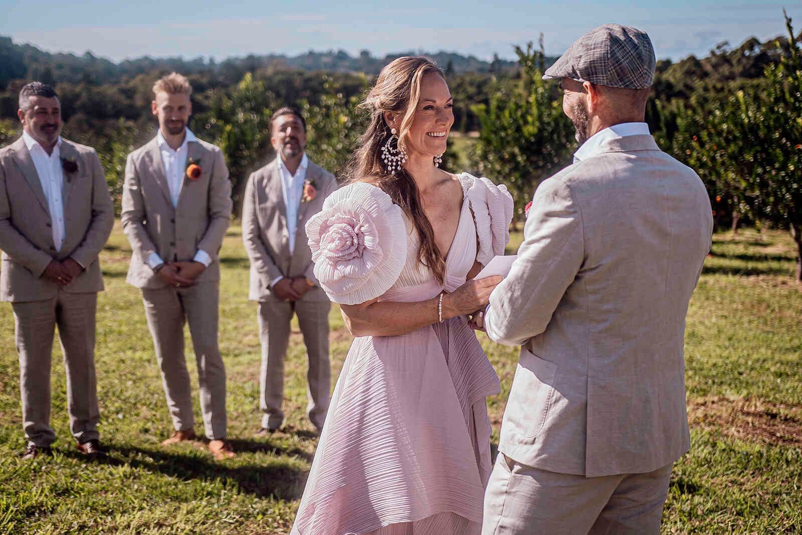 bride_groom_vows_outdoor_ceremony_pink_dress_tan_suit_0dcdc3d72b