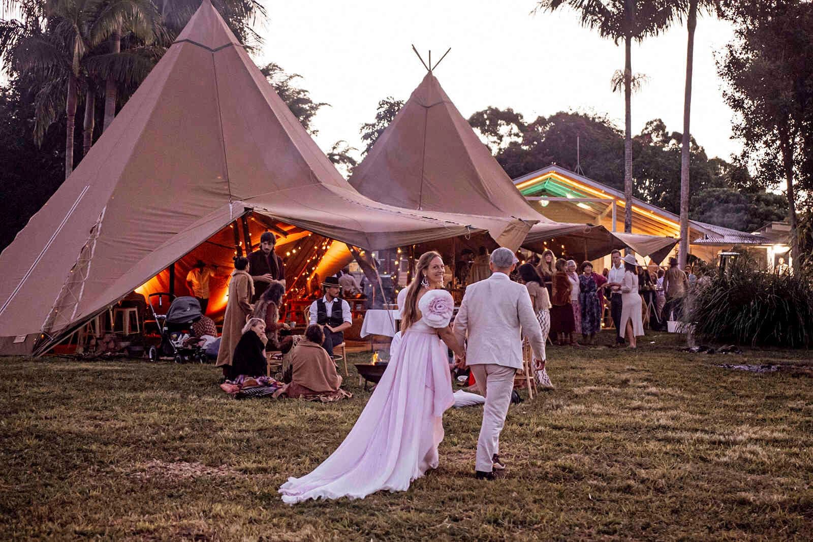 bride_groom_entering_teepee_reception_tents_evening_8c1389ec2d