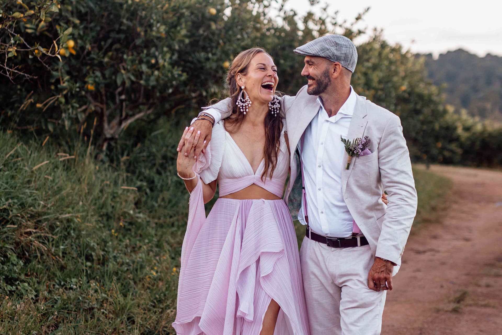bride_groom_walking_portrait_pink_dress_laughing_orchard_4393710e2c