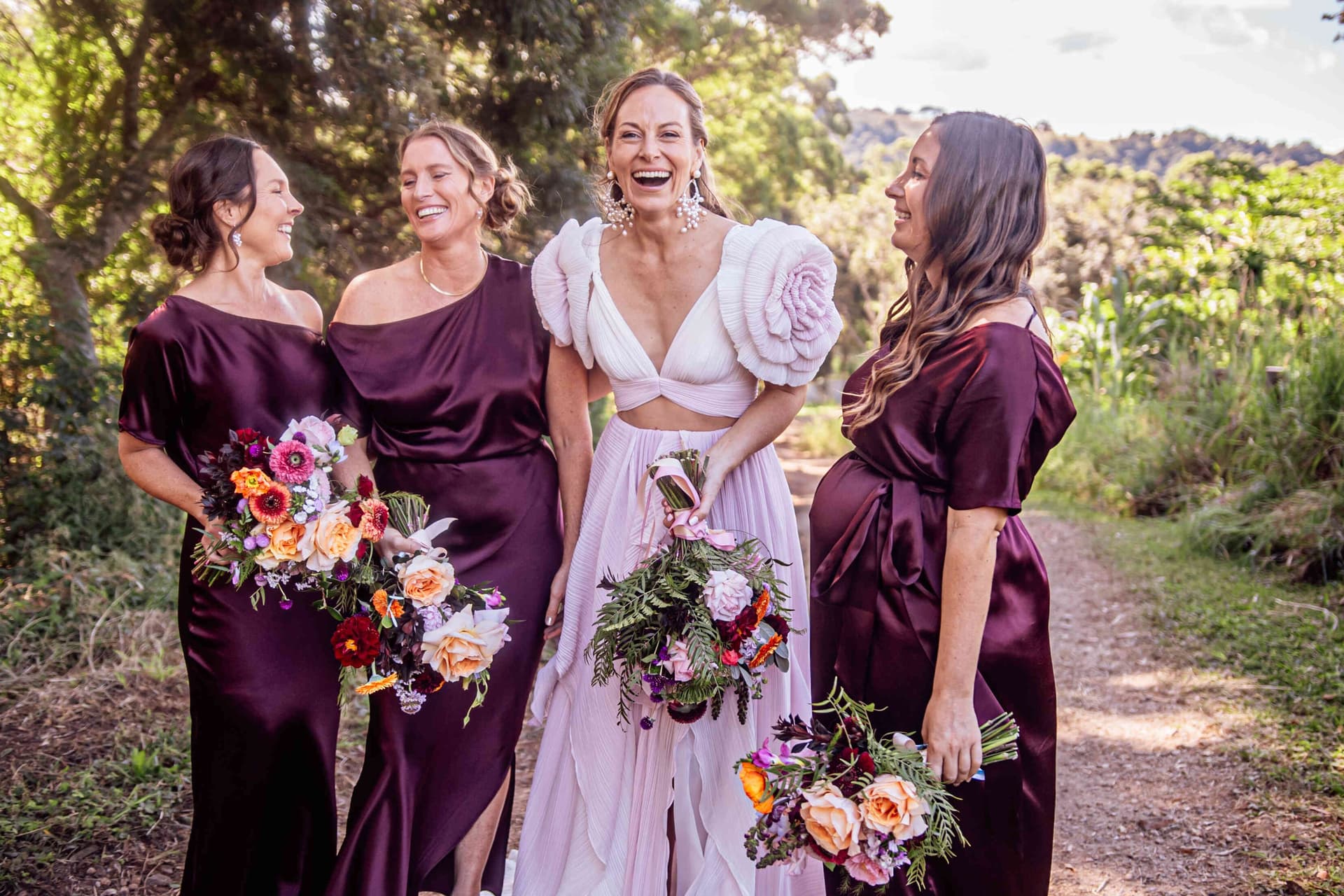 bride_bridesmaids_laughing_pink_burgundy_dresses_portrait_7ccc99cb21