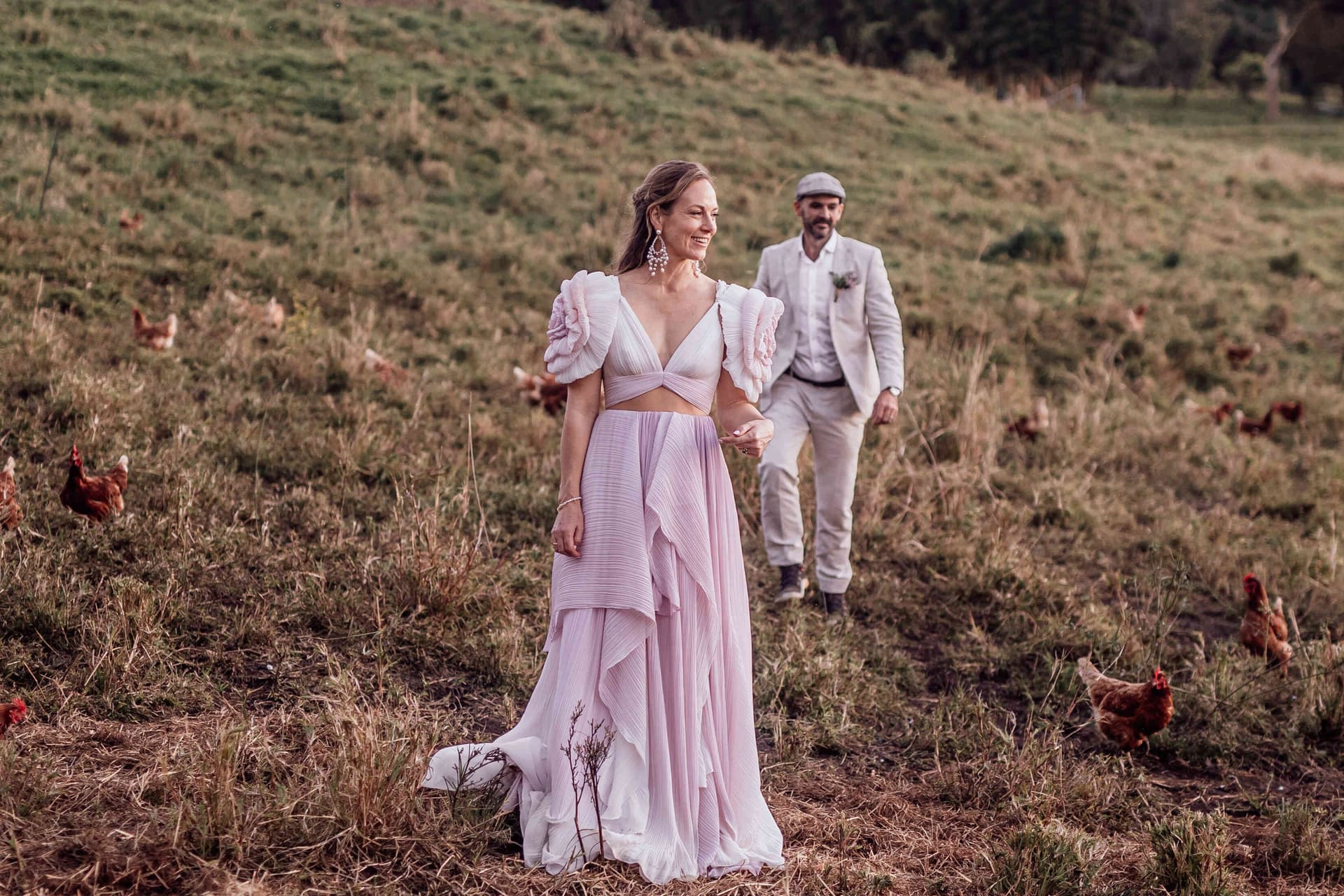 bride_groom_walking_through_chickens_farm_field_portrait_2ed10fefd7