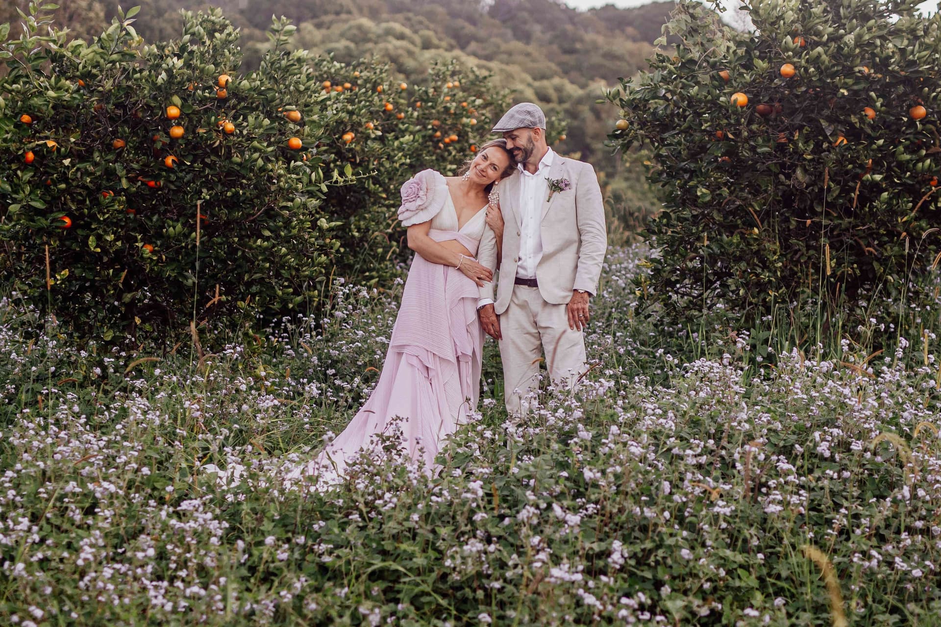 bride_groom_cuddling_orchard_flower_field_portrait_9363bae4ac
