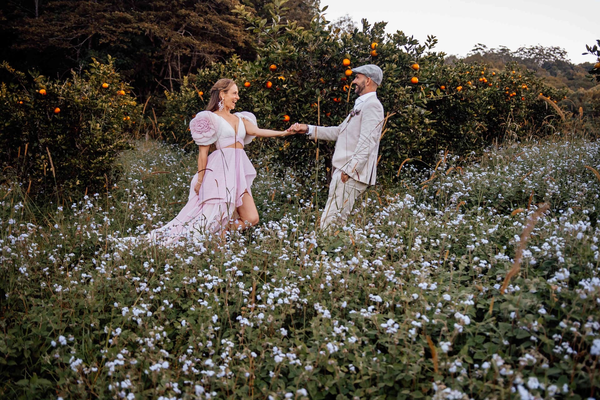 couple_holding_hands_flower_field_orchard_sunset_portrait_0368c39bd1