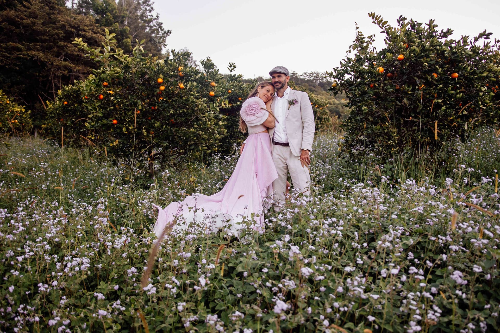 bride_groom_standing_in_flower_field_orchard_portrait_395f047943